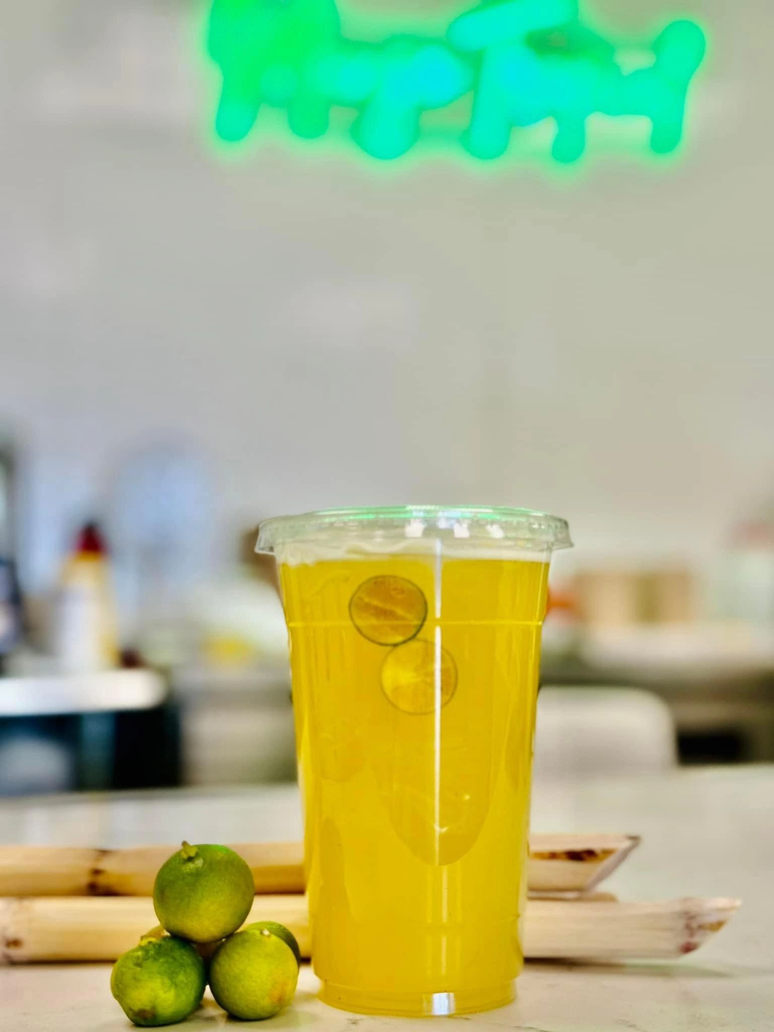 Fresh sugarcane juice with citrus and sugarcane stalks at Mango Tropical